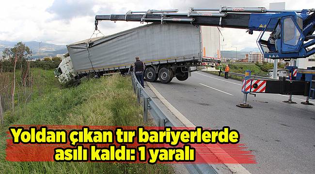 Yoldan çıkan tır bariyerlerde asılı kaldı: 1 yaralı