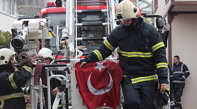 Yangına müdahele eden itfaiye eri duvardaki Türk Bayrağı için seferber oldu