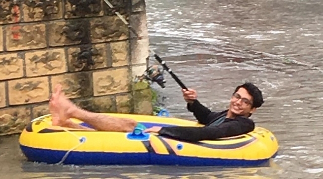 Göle dönen yolda şişme botuyla kürek çekti