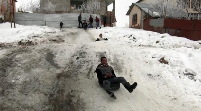 Çocuklar karın keyfini poşet ve plastik bidonlarla kayarak çıkarıyorlar